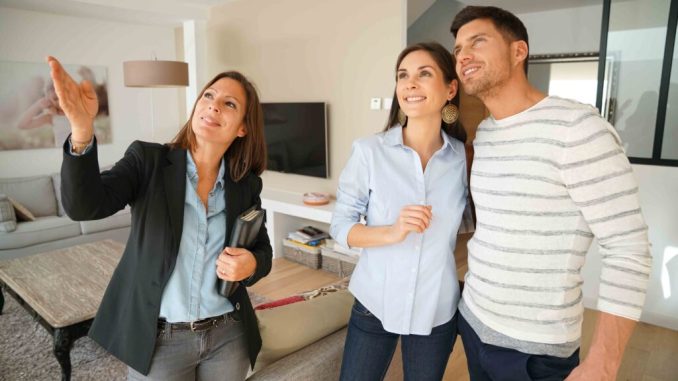 Couple with real-estate agent visiting house for sale